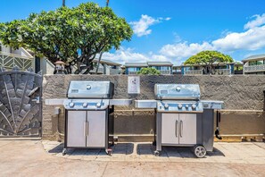 Two portable gas grills with wheels, a metal gate, and a sign prohibiting glass containers in the pool area. - Beautiful Ocean View 2 Bedroom Condo 1 Min Walk to Beach! (Kihei)