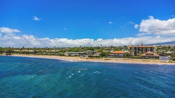 Ein Küstenhotel mit mehreren Gebäuden, einem Strand und klarem, blauem Wasser.