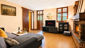 Una sala de estar con chimenea, televisor y sofá.
