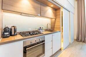 Eine moderne Küche mit Gasherd, Backofen und Kaffeemaschine.