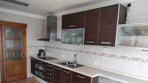 A kitchen with dark cabinets, a double sink, and a microwave. - Beachfront Apartment (S'Arenal)