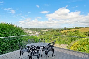 A deck with a table and chairs overlooking a scenic landscape. - Haven Near Dartmouth Ferry (Dartmouth)