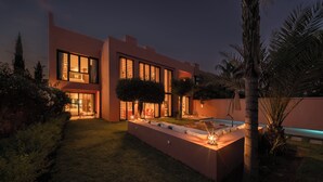 Ein modernes Haus mit gepflegtem Rasen, einem Schwimmbad und einer Terrassenfläche.