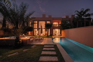 A modern house with a swimming pool, outdoor seating, and a well-maintained lawn. - Riad Majorelle – Al Maaden Golf – Marrakech (Marrakech)