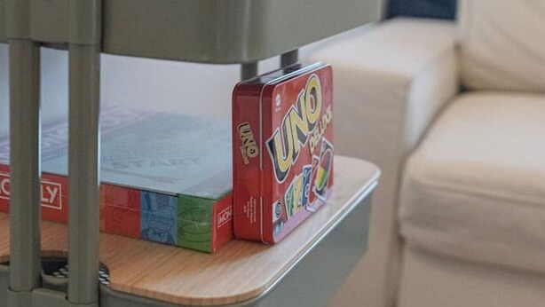 A metal shelf with books and a game box. - Cozy Studio • Swimming Pool • View of the Alps • Crans-Montana (Crans-Montana)