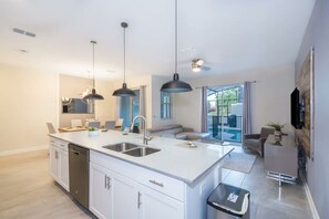A modern kitchen with a central island, built-in appliances, and pendant lighting. - 4BR w Private Pool Star Wars Room Resort 4993 (Kissimmee)