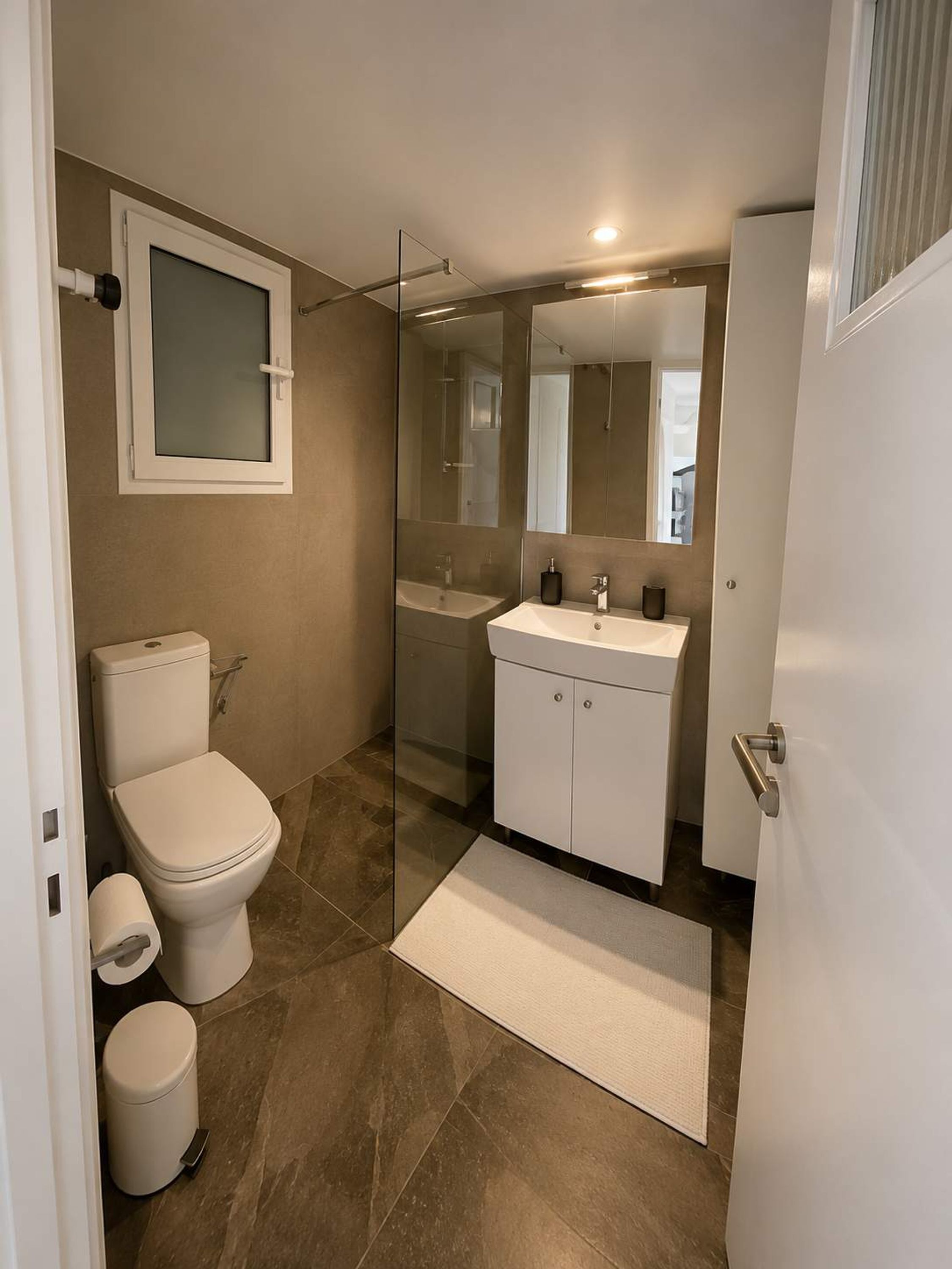 A modern bathroom with a toilet, sink, and shower area.