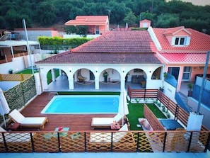 A residential property with a swimming pool, outdoor seating, and a covered patio area. - Indemela Corfu Lodge  (Karousades)