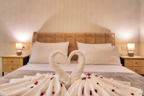 A hotel room with a bed, two nightstands, and a heart-shaped towel arrangement on the bed. - Indemela Corfu Lodge  (Karousades)