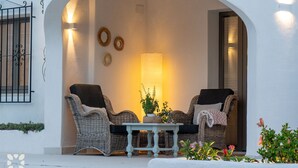 An outdoor seating area with wicker chairs, a table, and a lamp. - PALMERAS DEL MAR Villa by Abahana Villas (Teulada)