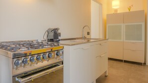 Uma cozinha compacta com fogão a gás, cafeteira e pia.
