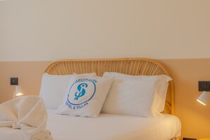A hotel room with a bed, pillows, a folded towel, and two wall-mounted lamps. - SG Family - Il Meriggio (Peschiera del Garda)