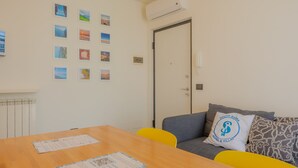 Um quarto com uma mesa de madeira, um sofá com um travesseiro e uma porta.