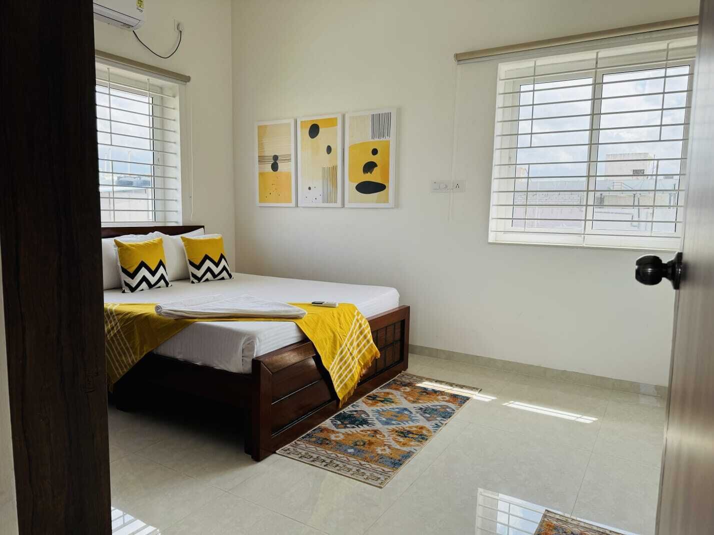 A bedroom with a bed, a window, and a door.