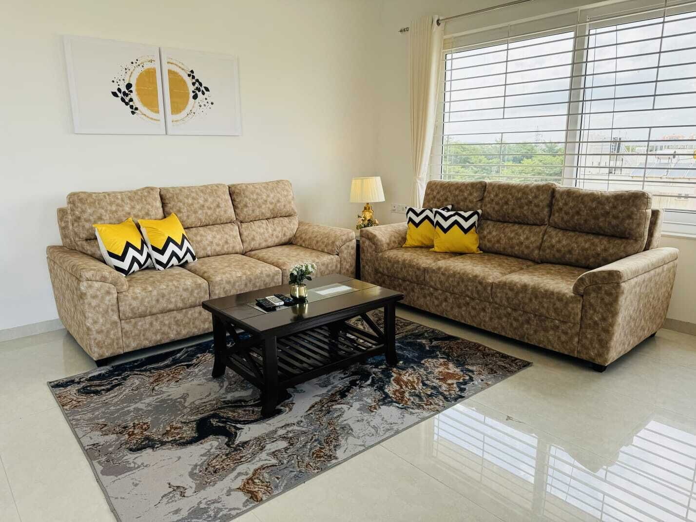 A living room with two sofas, a coffee table, and a patterned rug.
