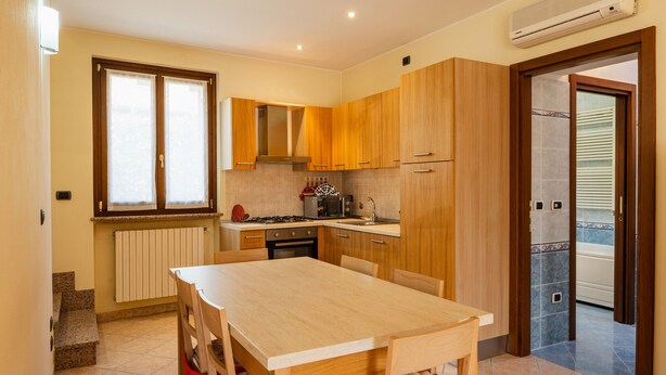 Una cocina moderna con armarios de madera, estufa a gas y horno empotrado.