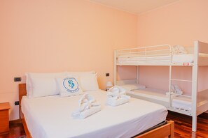 A hotel room with a bunk bed, a single bed, and a wooden nightstand. - SG Family - Casa Bertolini (Castelnuovo del Garda)