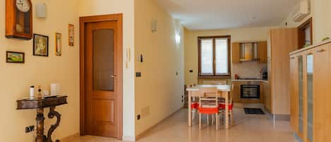 Una cocina moderna con armarios de madera, una mesa de comedor con sillas y un horno empotrado.