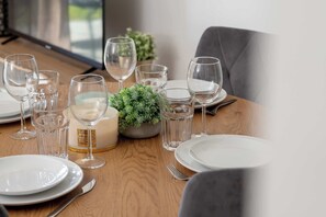 A dining table set with white plates, clear wine glasses, and a candle in a bowl. - Brown Apartment with Garden | Desk | Parking (Jastrzębia Góra)