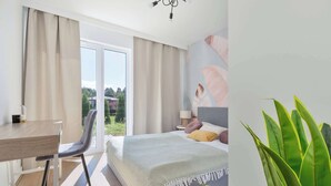 A modern bedroom with a bed, a desk, and a chair. - Brown Apartment with Garden | Desk | Parking (Jastrzębia Góra)