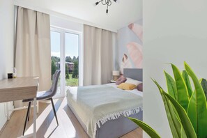 A modern bedroom with a bed, a desk, and a chair. - Brown Apartment with Garden | Desk | Parking (Jastrzębia Góra)