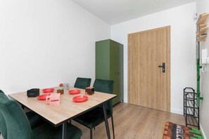 A room with a wooden table, green chairs, a green wardrobe, and a wooden door. - Minecraft-Inspired Apartment | Game Console (Jastrzębia Góra)