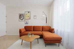 Ein Wohnzimmer mit Ecksofa, Couchtisch und Wandbildern.