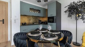 Une cuisine moderne dotée d’un four à micro-ondes encastré, d’une machine à café et d’un revêtement mural décoratif.