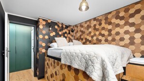 Ein Schlafzimmer mit einem Etagenbett, einer grünen Tür und einer Wand mit sechseckigem Muster.