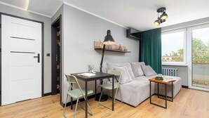 Ein kompakter Wohnbereich mit Küchenzeile, Essplatz und Sofa.