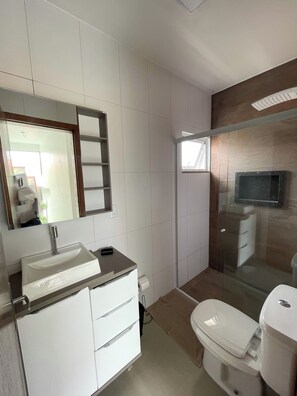 Un bagno moderno con lavandino, specchio e servizi igienici bianchi.