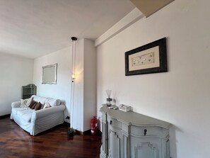 A room with a white sofa, a framed picture, a cabinet, and a fire extinguisher. - CASA DEL POZZO (Rapallo)
