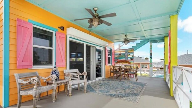 A covered porch with a ceiling fan, a dining table with chairs, and a bench. - Codakai the ultimate Spanish Wells family friendly getaway (Spanish Wells)