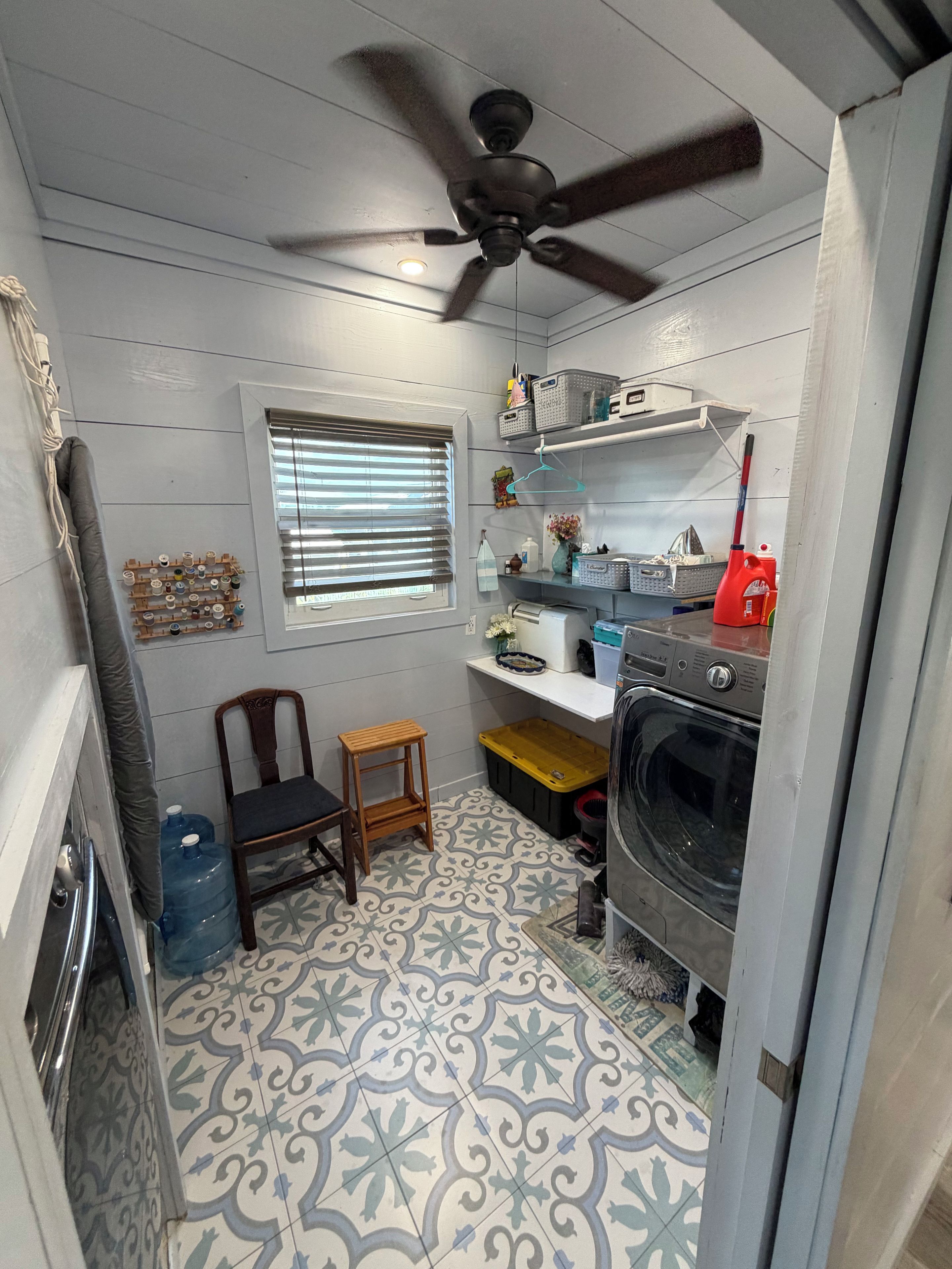 A compact kitchen with a ceiling fan, a built-in oven, and a patterned floor.