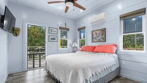 A bedroom with a bed, ceiling fan, air conditioning unit, and windows. - Codakai the ultimate Spanish Wells family friendly getaway (Spanish Wells)