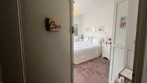 Ein Schlafzimmer mit Bett, Nachttisch, Kommode und Spiegel.
