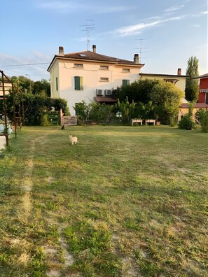 Un immobile residenziale con un prato, una casa con un camino e un'antenna parabolica.