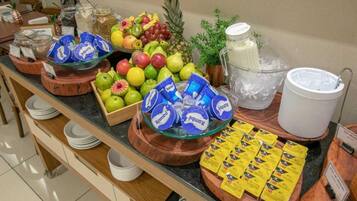 A buffet with fruits, yogurt, and cereal.