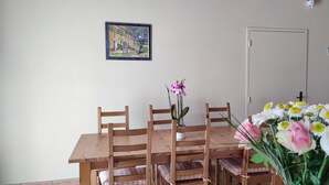 Ein Essbereich mit einem Holztisch und -stühlen, einem Gemälde an der Wand und einer Tür mit einem Schild.