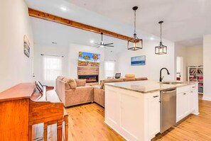 A modern kitchen with a central island, white cabinetry, and a built-in dishwasher. - New Home w/2 Masters 3-minutes to beach. Has pool and golf cart (North Myrtle Beach)