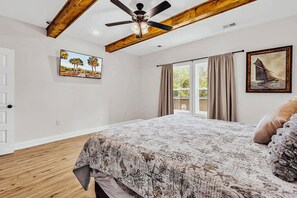 A bedroom with a bed, a ceiling fan, a window with curtains, and a door. - New Home w/2 Masters 3-minutes to beach. Has pool and golf cart (North Myrtle Beach)