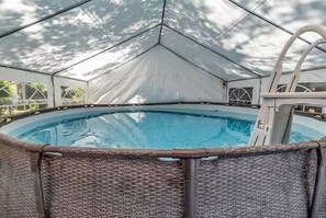 A covered swimming pool with a diving board and wicker chairs. - New Home w/2 Masters 3-minutes to beach. Has pool and golf cart (North Myrtle Beach)