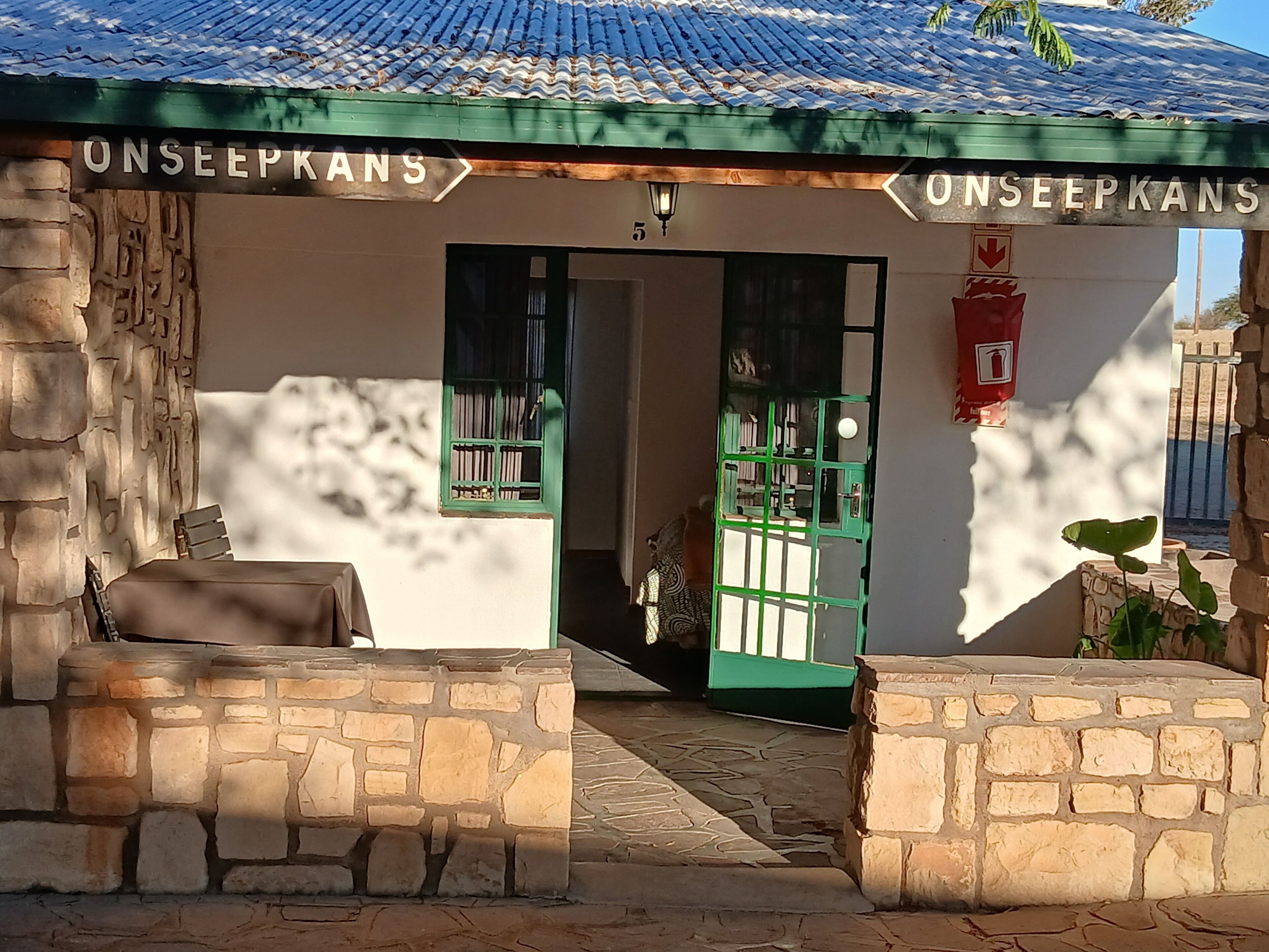 La entrada de un edificio con un cartel que dice 'ONSEEPKANS' y una verja verde.