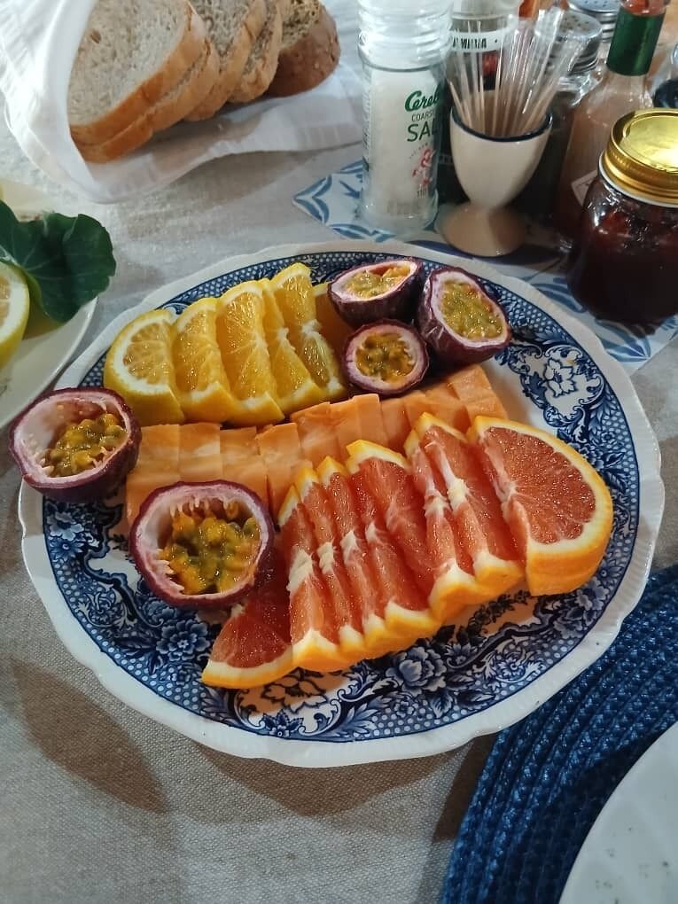 Ein Teller mit Obstscheiben und ein Einmachglas Marmelade.