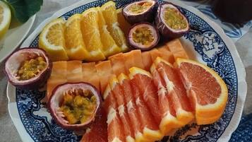 Ein Teller mit Obstscheiben und ein Einmachglas Marmelade.