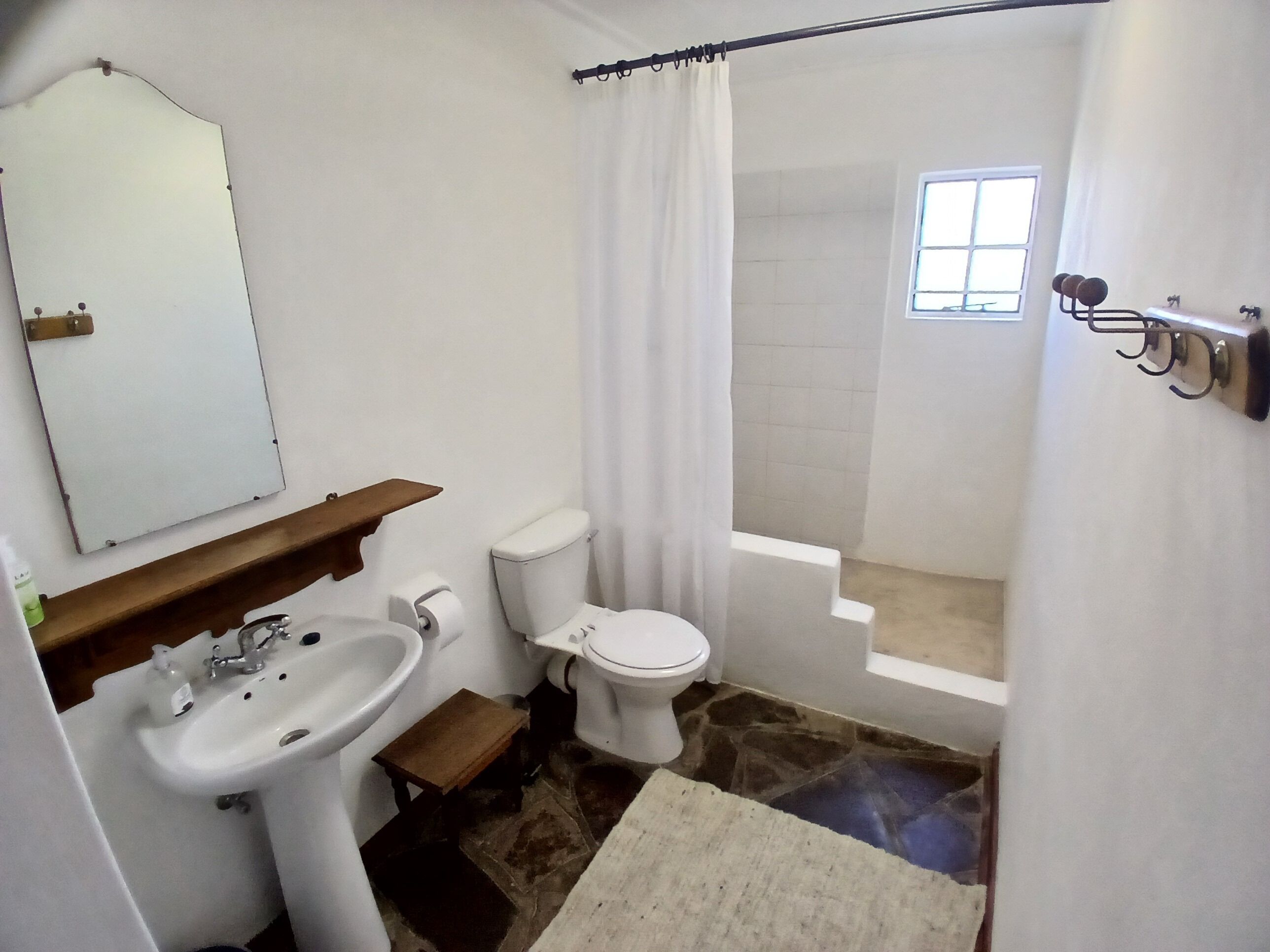 A bathroom with a sink, toilet, and shower area.