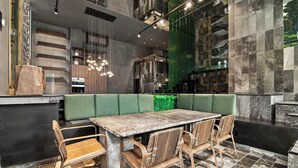 A modern dining area with a marble table, cushioned bench seating, and a green accent wall. - Rooftop Pool, Spa! Luxury 4BR Designer Tulum Villa (Tulum)