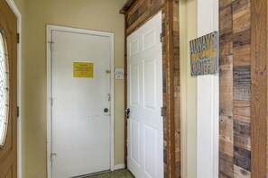 A hotel entrance with a closed white door, a welcome sign, a keypad lock, and a wooden wall with a 'Always Grateful' sign. - 10 Mi to Airport & Vintage Park! Quaint Apartment (Houston)