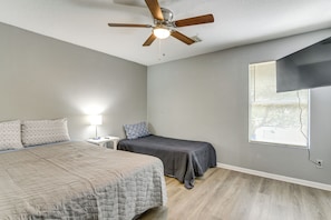 A bedroom with a bed, a nightstand, a desk, a ceiling fan, and a window with blinds. - 10 Mi to Airport & Vintage Park! Quaint Apartment (Houston)