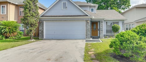 A residential house with a garage, a front yard with a lawn, and a driveway.